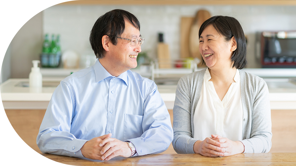 笑顔で会話するご年配のご夫婦