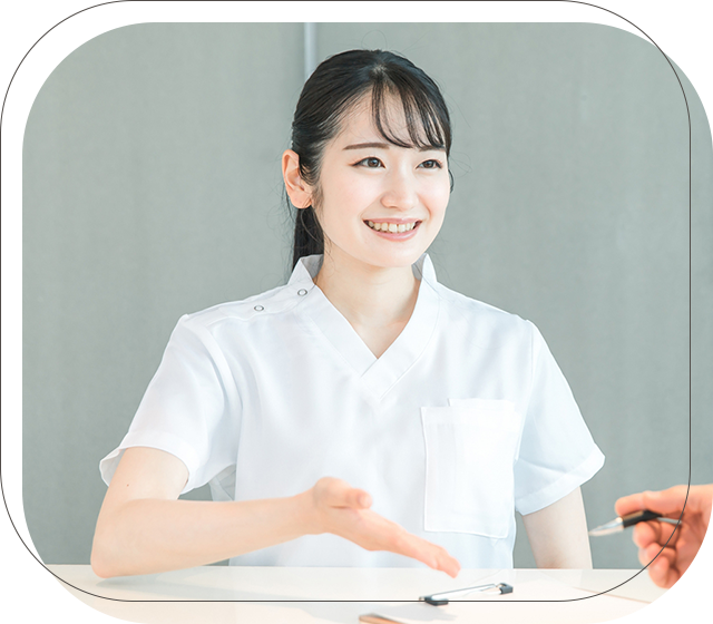 受付スタッフが笑顔で説明している写真